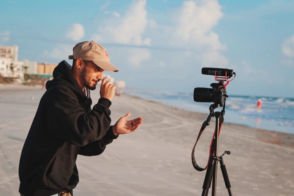 a young man with a heat in front of a camera on a tripod