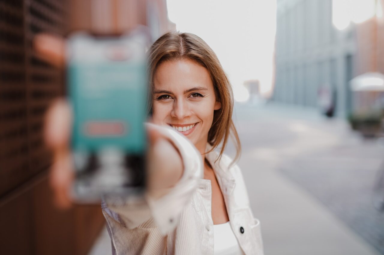 a happy girl with a phone in a road